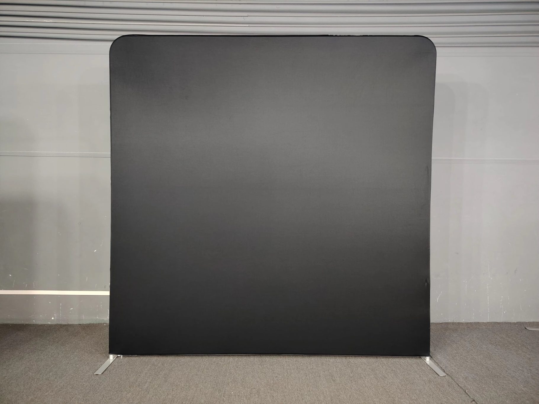 Schwarzer, einfarbiger Hintergrund auf einem Bodenbelag, ohne andere Elemente.