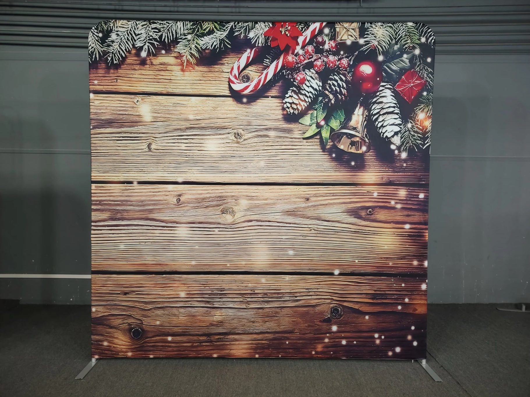 Holzwand mit Weihnachtsdekoration, Tannenzweigen und Ornamenten.