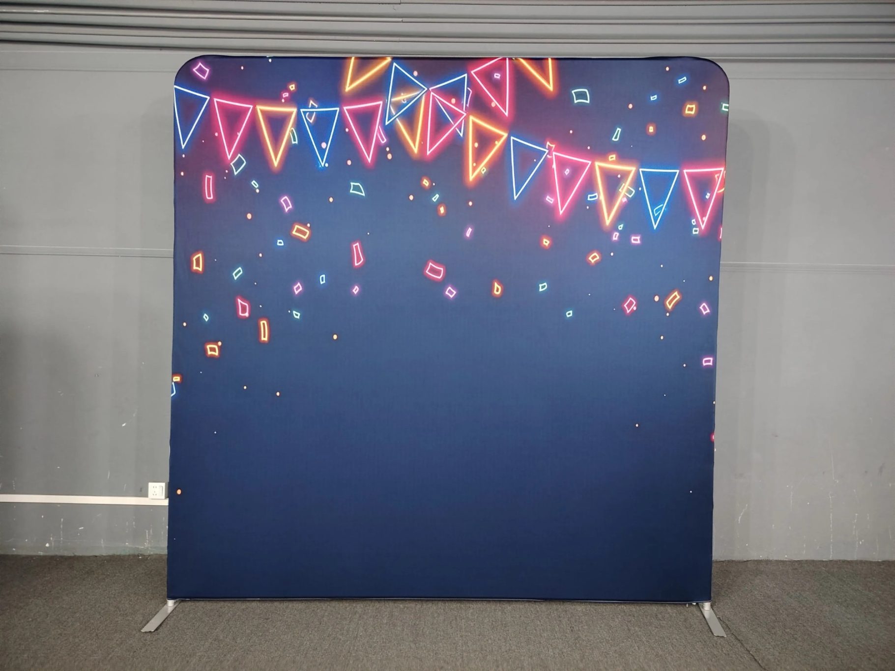 Blaue Wand mit bunten Wimpeln und Konfetti-Design, feierliche Atmosphäre.