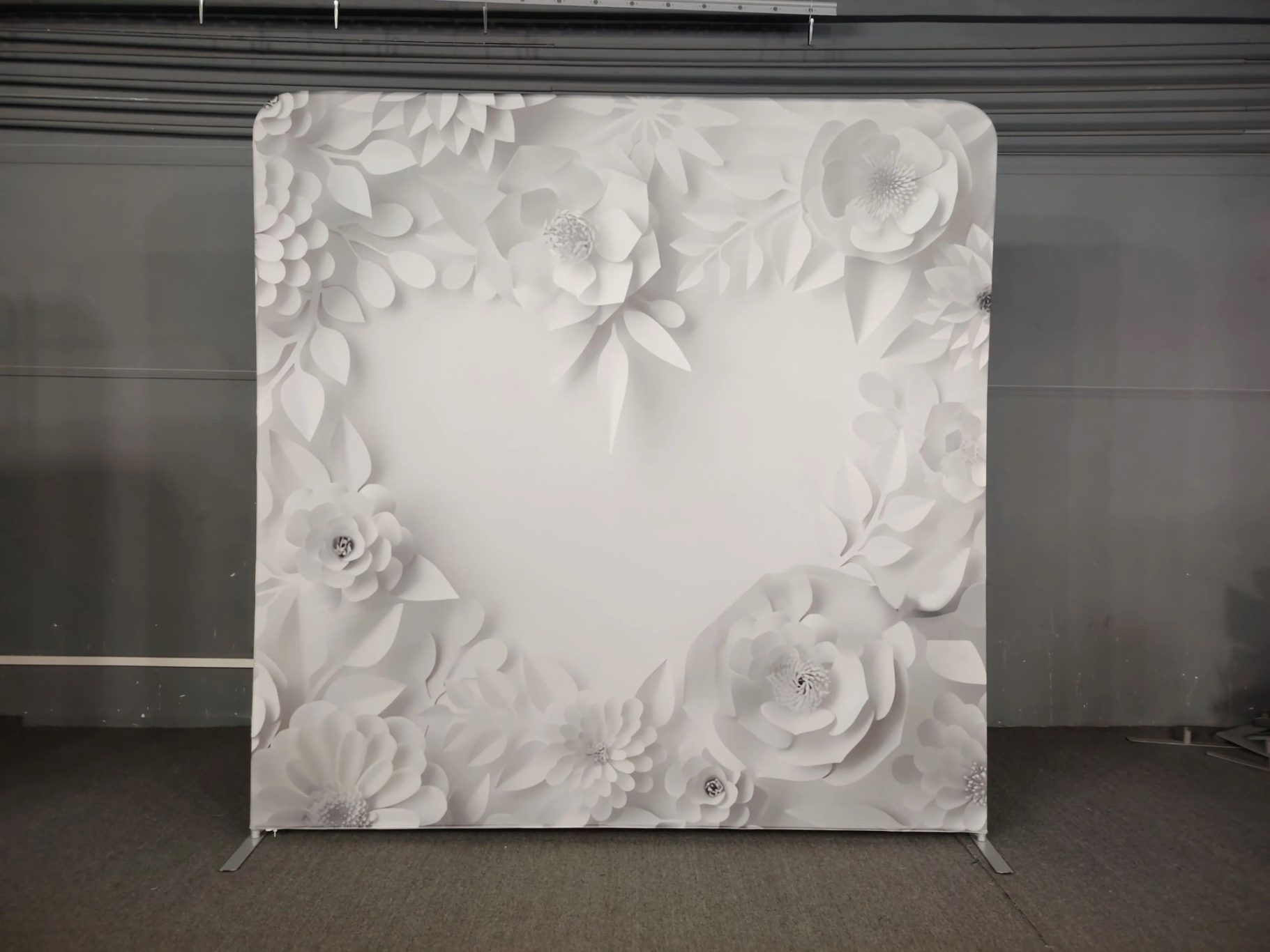 Weißer Hintergrund mit dreidimensionalen Blumen und Herzmotiv.