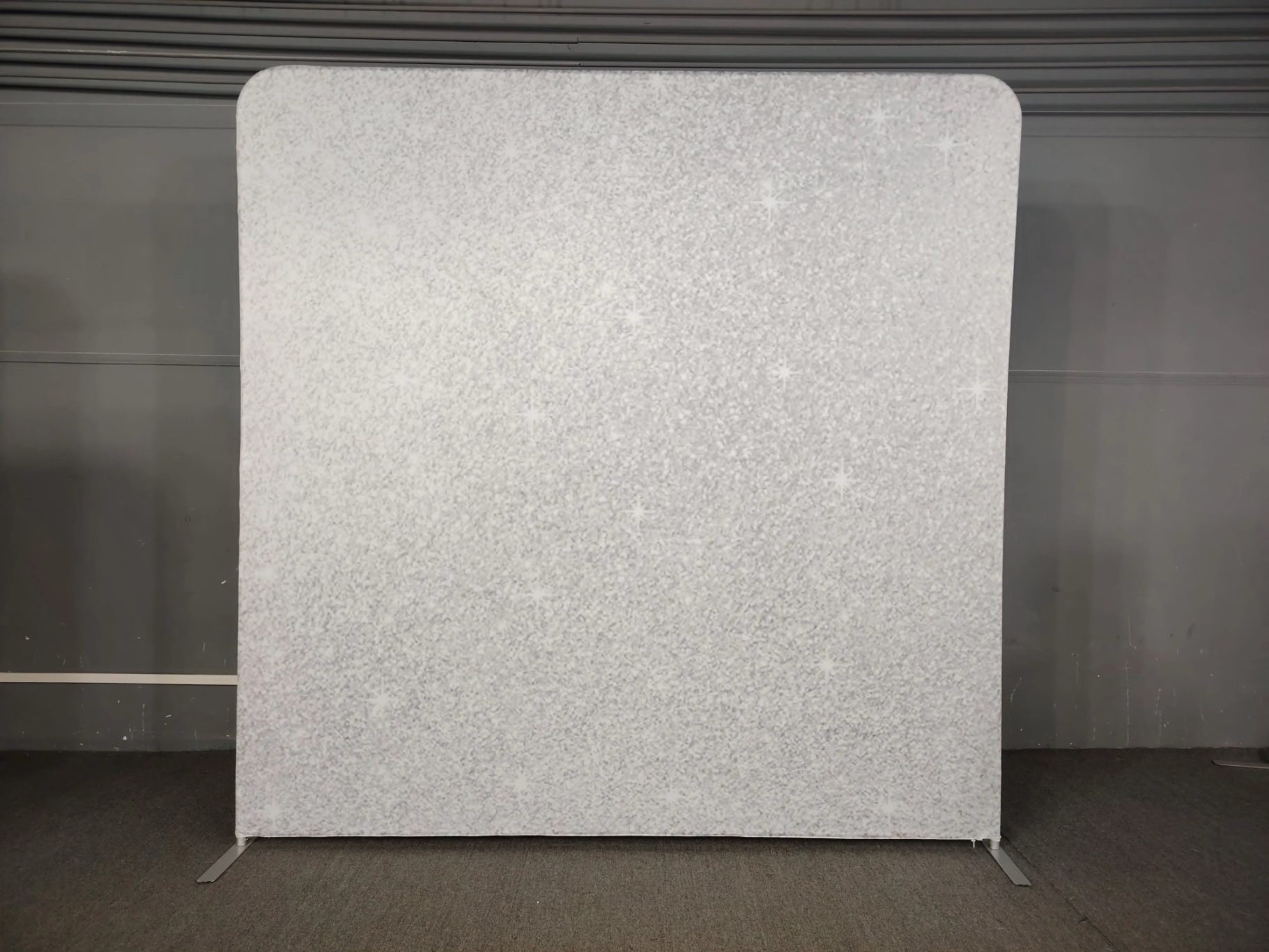 Ein glitzernder, silberner Fotohintergrund mit funkelnden Akzenten.